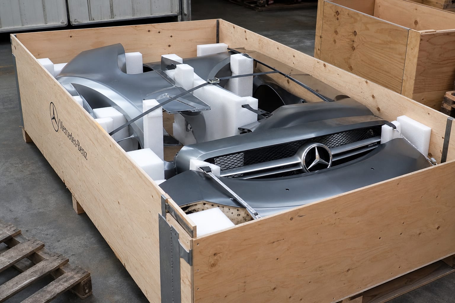 Foam-blocked body panels strapped inside a plywood export crate ready for shipping